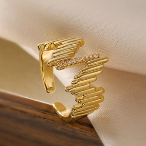 Irregular gold wave ring with sparkling zircons on elegant beige silk fabric