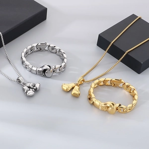 Gold and silver Cuban link jewelry sets with boxing glove pendants on display stands