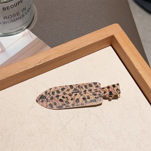 Detailed view of leopard print BB hair clips in pink and brown with PU leather texture
