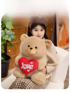 Close-up of soft brown teddy bear holding a red Love heart, shown in a cozy embrace