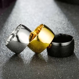 Detailed view of wide titanium steel rings in silver, gold, and black with mirror finish