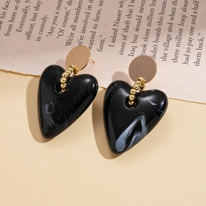 Detail of heart earrings with black marble resin pendant and golden round stud