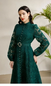 Detail view of dark green lace dress with pearl buttons and fine embroidery texture