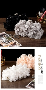 Detail of floral evening clutch bags in four colors with 3D petals and metal clasp