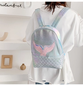 Detail of mermaid tail embroidery and iridescent scale texture on light blue backpack