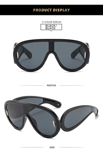 Front and side views of black Y2K oversized wrap-around sunglasses with gold metal accents