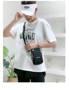 Detail of black nylon crossbody phone bag featuring gold zippers and adjustable strap