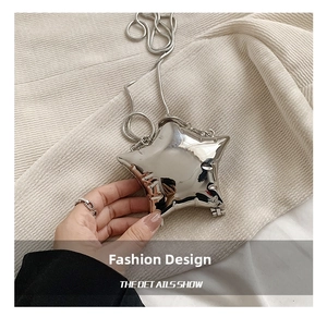 Close-up of a silver star-shaped mini bag with mirror finish and snake chain strap
