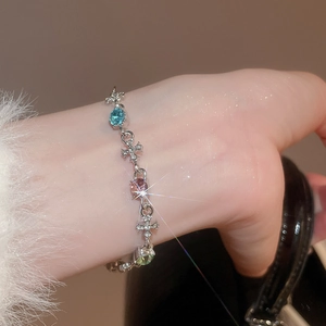 Detailed view of silver bracelet featuring cross charms and colorful pastel gemstones