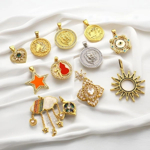 Close-up of assorted gold and silver sun and heart charms with zircon on white silk