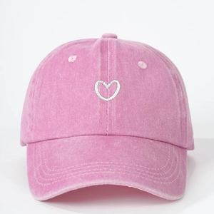 Pink washed cotton baseball cap with white heart embroidery and curved brim in retro style