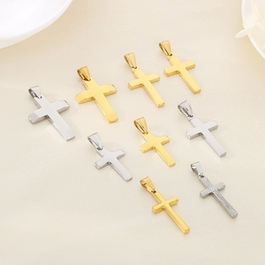 Detailed close-up of various sizes of polished gold and silver cross pendants in steel