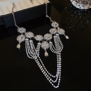 Detailed view of silver multi-layer tassel necklace with rhinestones and floral pattern