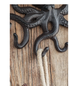 Nahaufnahme von rustikalem Kraken-Haken aus Gusseisen mit Tentakeln an einer Holzwand