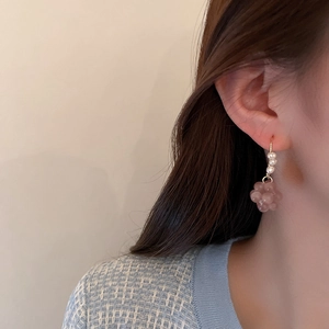 Detailed close-up of a model wearing butterfly pearl earrings with pink crystal beads