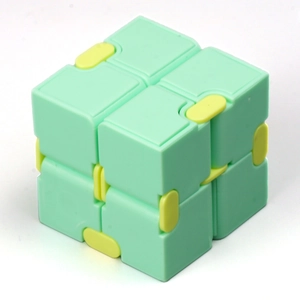 Detailed view of light green and yellow Infinity Cube toy showing folding mechanics