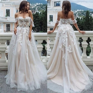 Elegant white lace wedding dress with off-shoulder neckline and long tulle A-line skirt