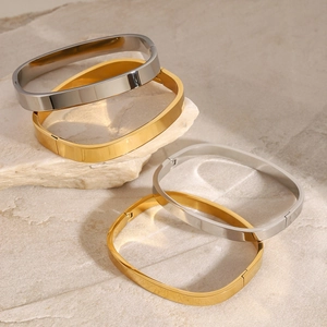 Classic square stainless steel bracelets in gold and silver finish on a stone surface