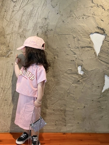 Girl in pink outfit carrying a shiny silver sequined crossbody chain bag for kids