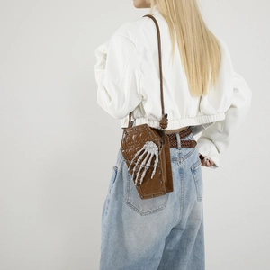 Gothic coffin-shaped brown crossbody bag featuring a white 3D skeleton hand design