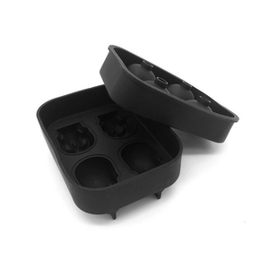 Detail view of black silicone ice mold creating four realistic 3D skull shaped ice cubes