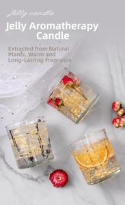 Macro shot of jelly candles with dried flowers, orange slices, and gold foil in glass