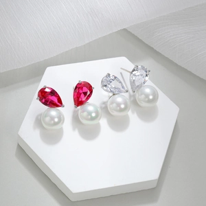 Luxury AAA zircon teardrop earrings with round white pearls on a white hexagonal stand