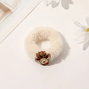 Detailed close-up of a plush beige scrunchie with a cute reindeer Christmas ornament