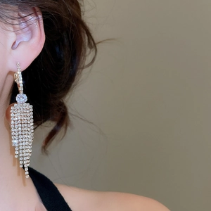 Detail of luxury long tassel drop earrings with sparkling rhinestones and silver plating