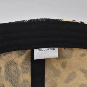 Detail shot of leopard print cotton baseball cap interior with 100% cotton wash label
