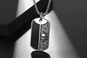Detail of titanium steel dog tag necklace with black panel and silver skull relief