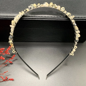 Detail of handmade crystal crown headband with beige stone chips on a black frame