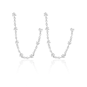 Close-up of silver chain earrings with zircon tassels on a white background with reflection