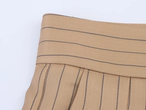 Detail of waist stitching and pleated texture on camel striped linen blend wide trousers