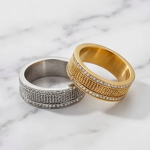 Detail of silver and gold punk rings with woven metal texture and pavé set crystals