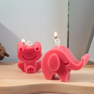 Roze cartoon kikker en olifant kaarsen brandend op een houten tafel met zacht licht