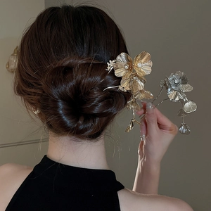 Detail of flower hair pin with sparkling diamonds and metal tassels on an elegant updo