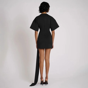 Rear view of black mini dress featuring structured flared sleeves and a long sash detail