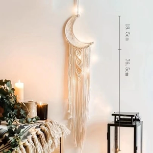 Handwoven beige cotton moon tapestry with LED lights in bohemian home decor setting