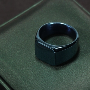 Detailed top-down view of a minimalist square signet ring in polished dark blue steel