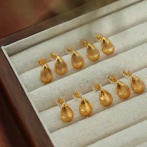 Elegant gold teardrop earrings set with shell-like vertical stripes in a wooden box