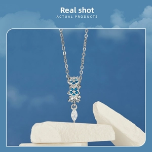 Detail of S925 silver flower pendant with blue enamel petals and marquise cut zircon