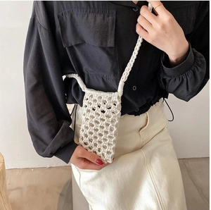 Detail of hand-woven white cotton mobile phone bag with intricate mesh pattern