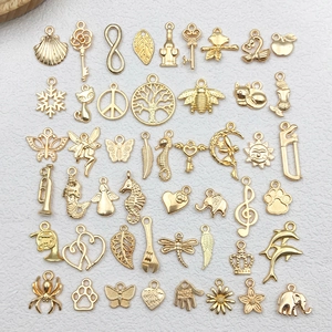Flat lay of gold DIY jewelry charms including shells, musical notes, and animals