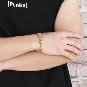Detail of gold-tone double wolf head chain bracelet in vintage punk viking style