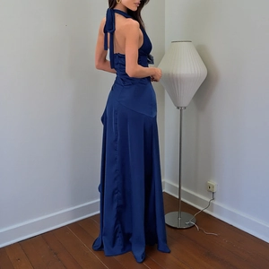 Detail of navy blue satin backless maxi dress showing the elegant cut and fabric sheen