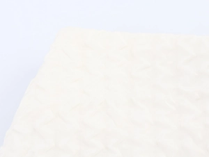 Détail macro du tissu matelassé crème avec motif géométrique élégant en relief de losanges