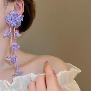 Detail of purple floral chiffon tassel earrings with beads on a model for vacation style