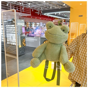 Detail of green plush frog backpack showing soft texture and adjustable shoulder straps