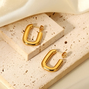 Minimalist 18K gold-plated U-shaped rectangular earrings on beige travertine with silk